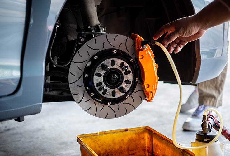 Car mechanic or serviceman disassembly and checking a disc brake