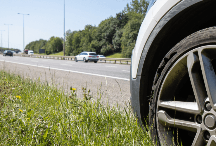 Car with tyre blow out at side of M25 Motorway