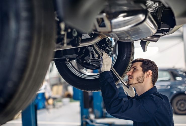 Mechanic examining car suspension