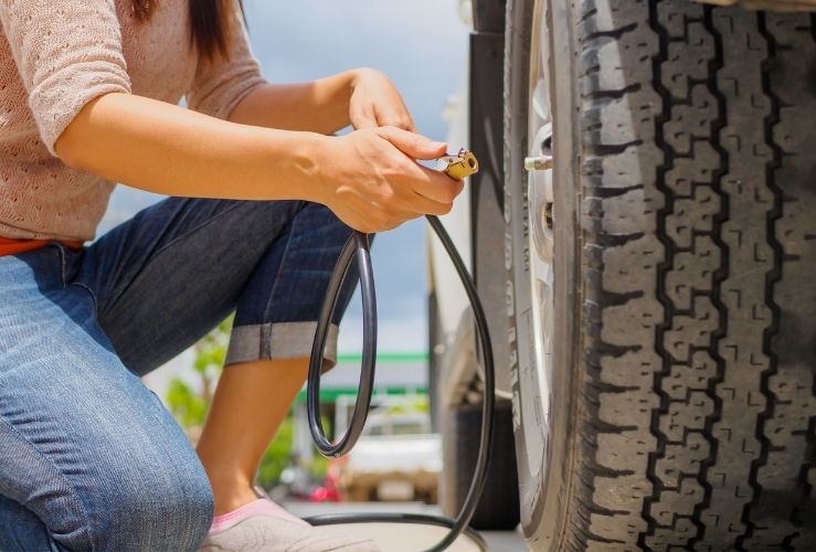 Woman inflating car tyre