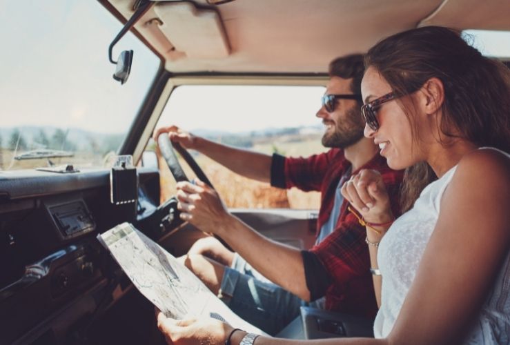 Man driving in sunglasses with female passenger