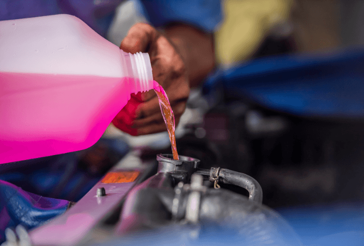 Mechanic adding coolant to car