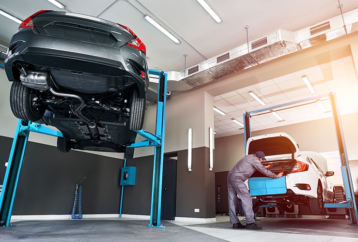 car being lifted up by a hydraulic machine for a technician