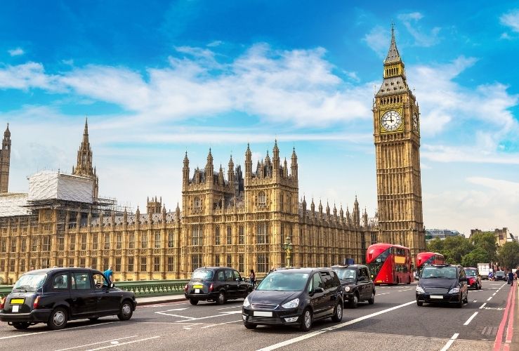 Cars driving past Houses of Parliament in London