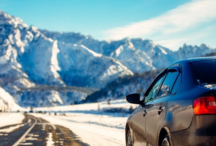 Car driving on snowy road in mountains