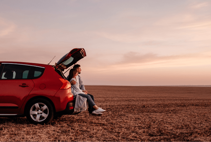 Happy young couple with their ideal car