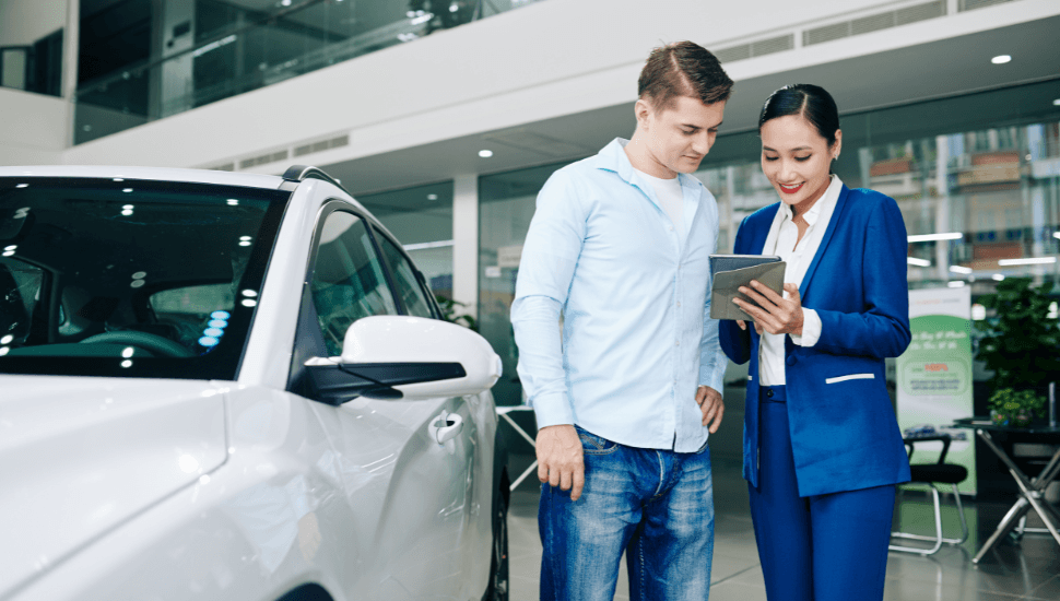 Man arranging to test drive a car with salesperson, at a car dealership