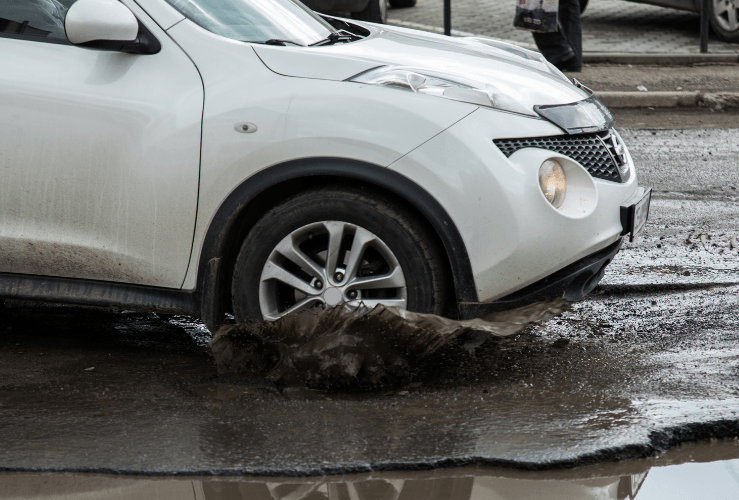 Car driving through flooded puddle