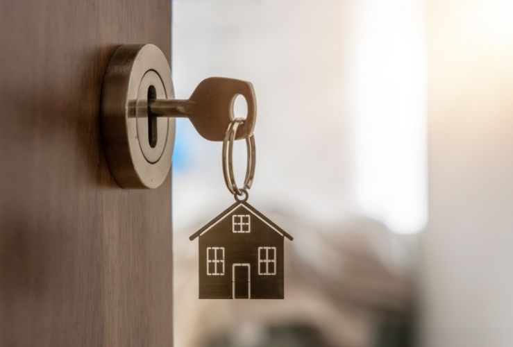 Image of key in front door of home