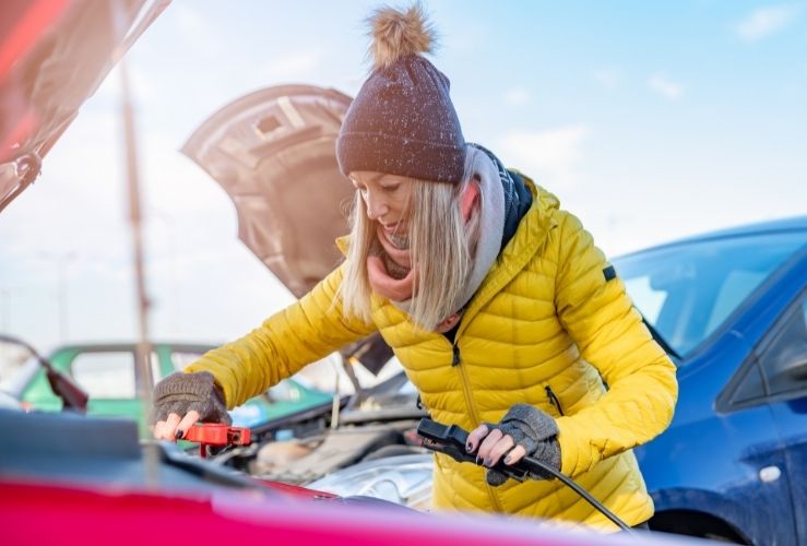 woman with jump leads in winter