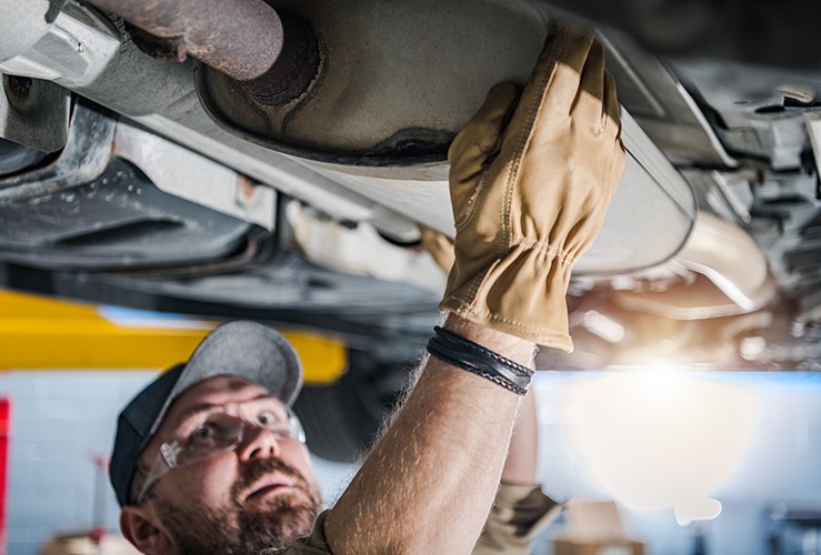 Mechanic performing catalytic converter check